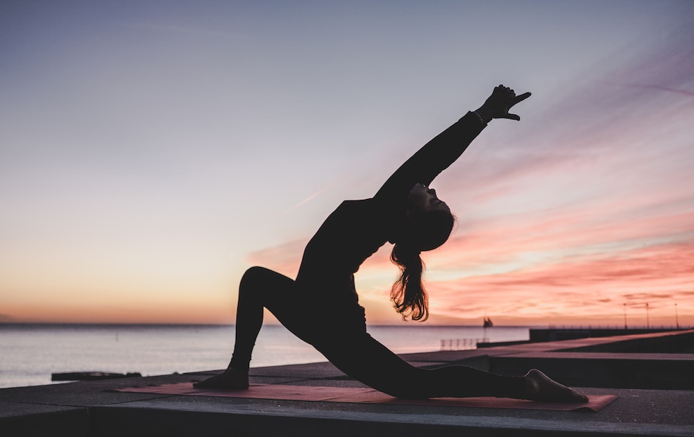 lady doing yoga at sunset